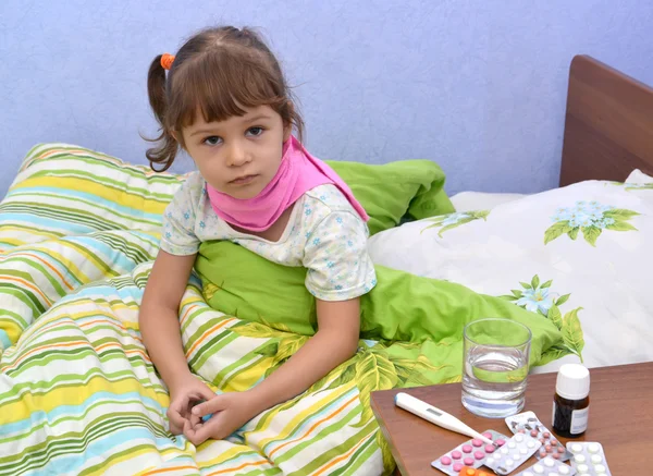 La bambina malata si siede in un letto — Foto Stock