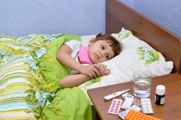 A menina doente triste está em uma cama — Fotografia de Stock