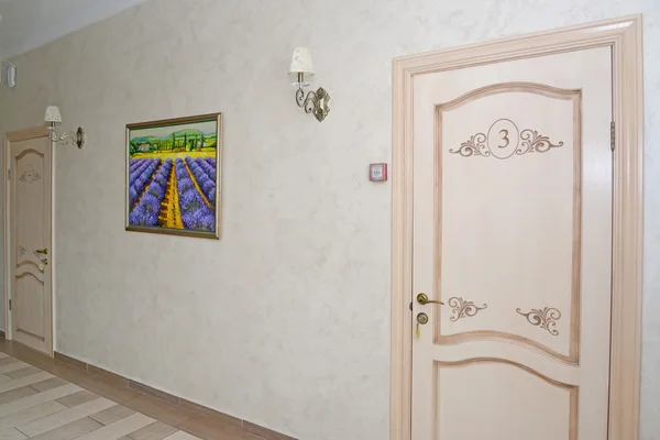 Corridor of hotel with white doors in numbers and a picture on a — Stock Photo, Image