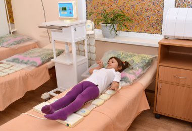 Küçük kız bir magnetotherapy prosedürü alır. Physioth