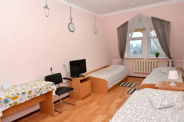 Třílůžkový pokoj hotelu se seznamem zdi — Stock fotografie