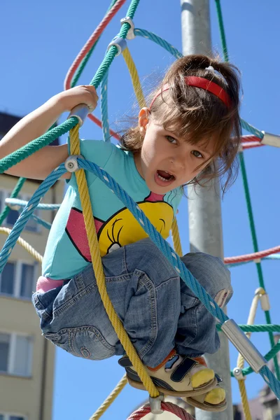 Het kleine meisje schreeuwt met angst op de top van een piramide touw — Stockfoto