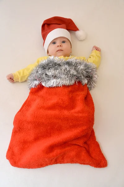 Barnet i en kostym av jultomten på en ljus ba — Stockfoto