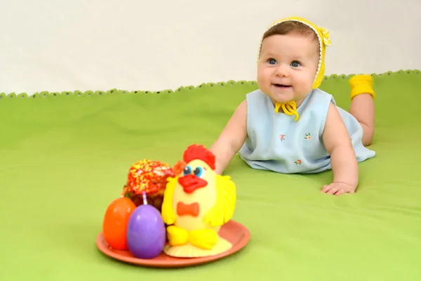 El bebé alegre con un entretenimiento de Pascua sobre un fondo verde — Foto de Stock
