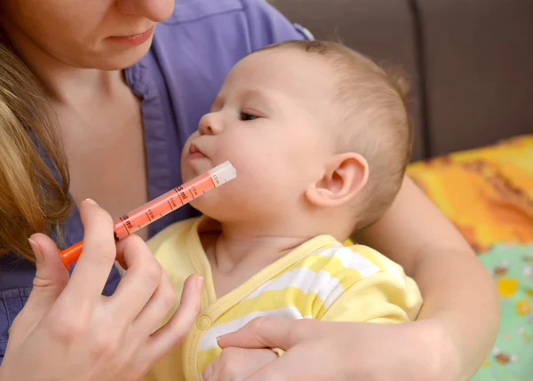 Das kranke Baby weigert sich, Medikamente mit dem Batcher einzunehmen. Behandlung — Stockfoto