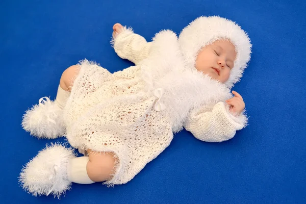 Das schlafende Baby im Neujahrsanzug der Schneeflocke auf einem blu — Stockfoto