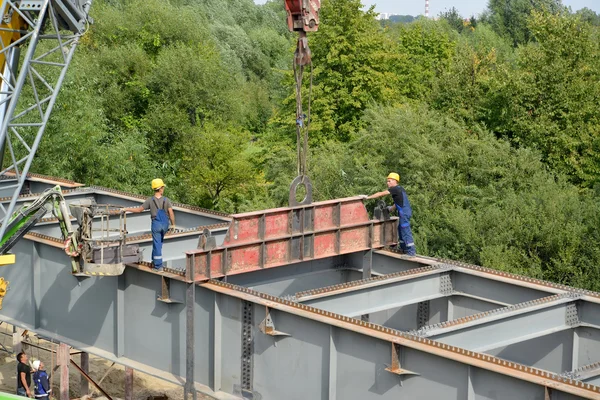 Калінінград, Російська Федерація - 24 серпня 2015: Slingers встановити металеві конструкції. Будівництво дороги платформи — стокове фото