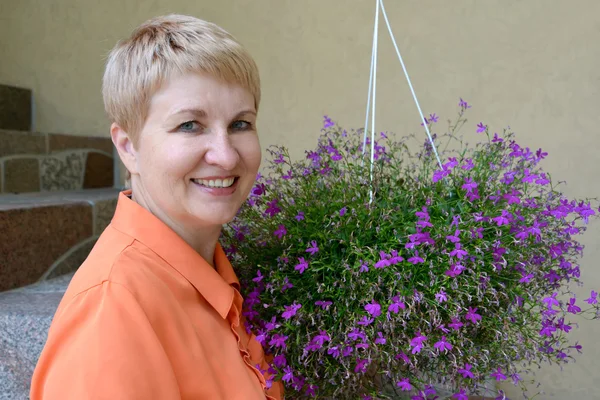 Portrait of the woman of average years with decorative flowers a — Stock Photo, Image