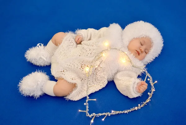 O bebê dormindo no terno de um Ano Novo do Floco de Neve com o — Fotografia de Stock