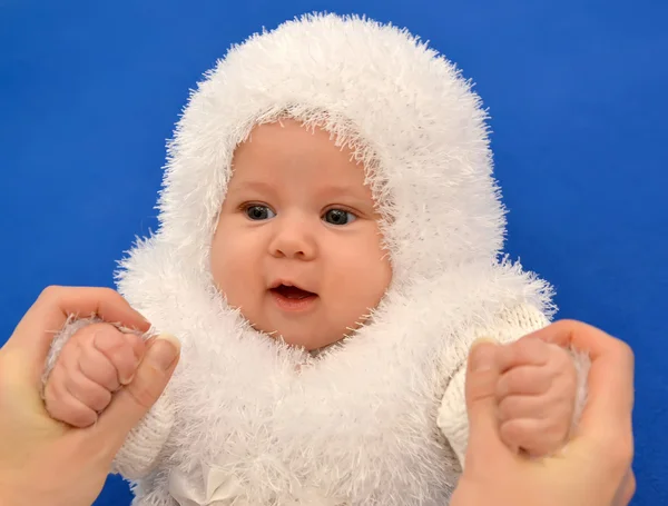 Weibliche Hände halten das Baby im Neujahrsanzug der Schneeflocke — Stockfoto