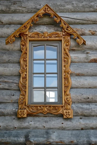 Fönster med trä snidad dörrramar på en timrade vägg — Stockfoto