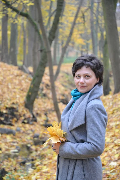 Retrato da mulher de anos médios com folhas de bordo amarelas — Fotografia de Stock