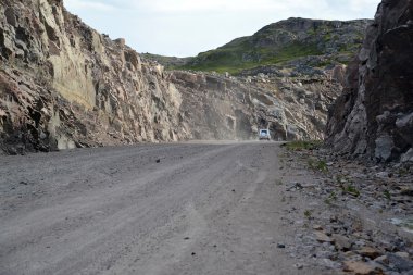 Dirt road in development of mountain rocky breeds. Kola Peninsul