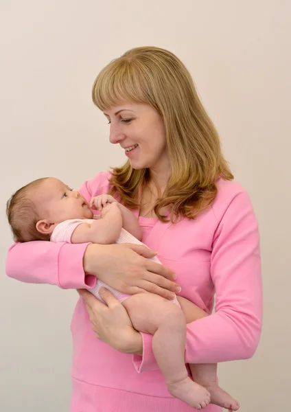 A jovem feliz segura nas mãos do bebê — Fotografia de Stock