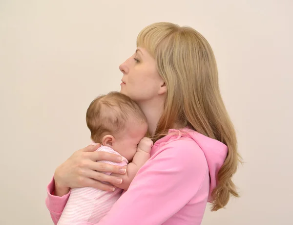 Die junge Frau umarmt das weinende Baby — Stockfoto