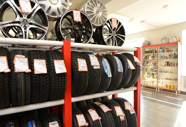 KALINININGRAD, RUSIA - 03 DE OCTUBRE. 2015: Un estante con neumáticos y llantas en un piso comercial. Tienda de un centro autotécnico — Foto de Stock