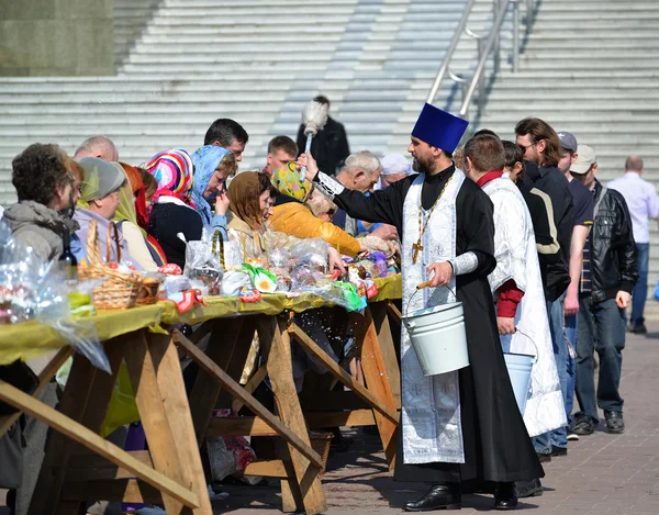 Kaliningrad, Rusland - 11 April 2015: De orthodoxe priester wijdt gelovigen en Pasen gebak voor Pasen — Stockfoto