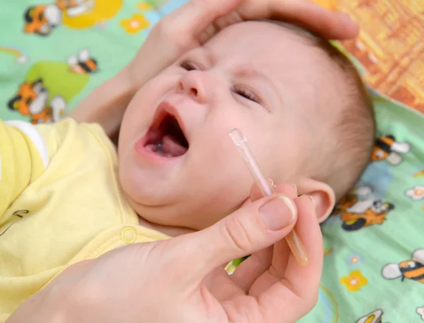 La femme creuse des gouttes dans le nez du bébé malade qui pleure. Traiter — Photo