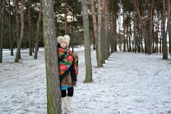 Kobieta lat średnie koszty w młodym sosnowym lasem. Zimowy krajobraz — Zdjęcie stockowe