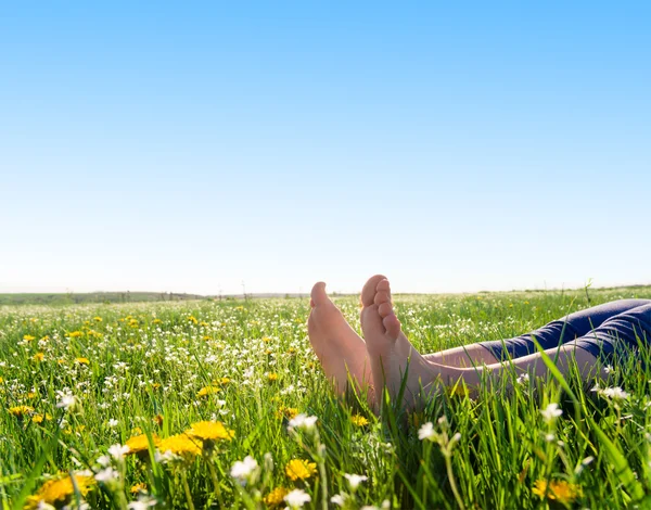 Bare feet on spring grass and flowers — Stock Photo, Image