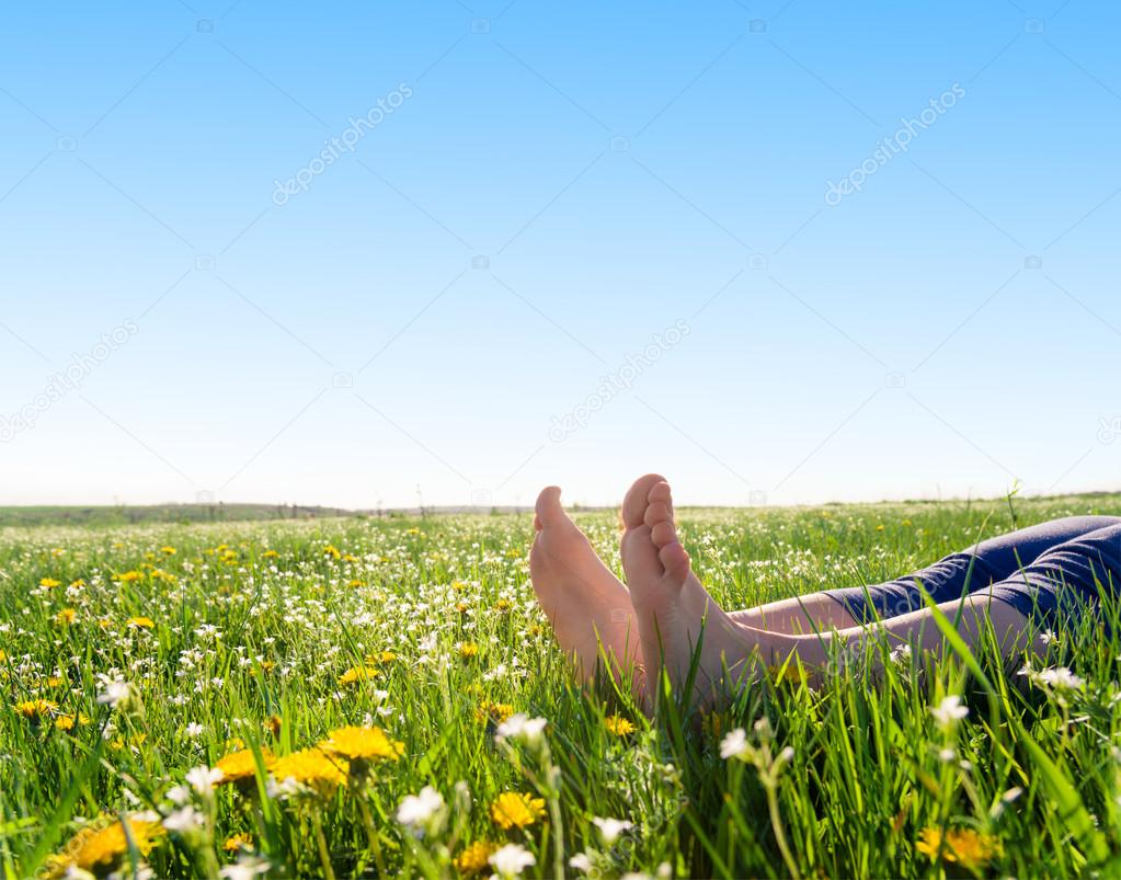 bare feet on spring grass and flowers