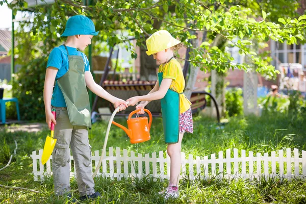 Садоводство и полив детей — стоковое фото