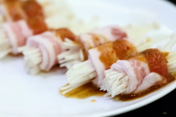 Raw bacon wrapped with needle mushroom — Stock Photo, Image