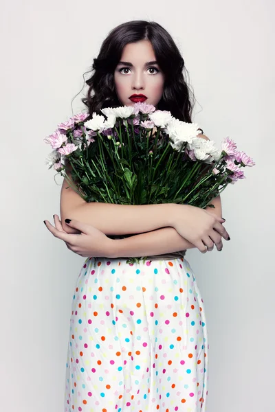 Glamouröses Porträt einer Brünetten mit einem Kleid aus Erbsen. Stockfoto