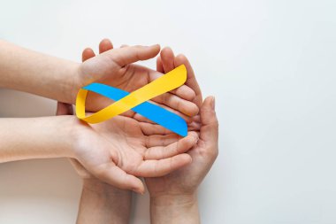 Dünya Down Sendromu Sendromu Günü 'ne yardım eden mavi sarı farkındalık kurdelesi. 21 Mart. Down sendromu olan hastalara ve Thorasic Outlet Sendromu olan hastalara destek artıyor.)