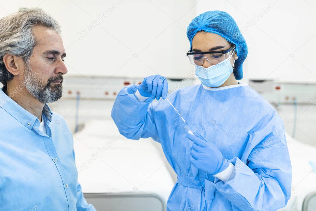 Mature man getting PCR test for coronavirus during appointment at doctor's office. Doctor performs coronavirus swab PCR test while wearing face protective mask during covid-19 pandemic.