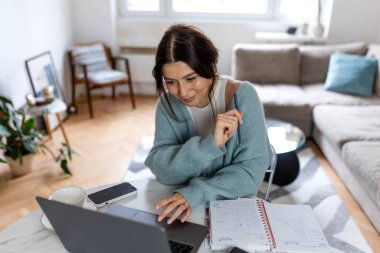 Ev Kadınları Çalışma Alanında Dizüstü bilgisayar ve Yazı Odaklı İş Kadını. Modern Parlak Daire İçlerinde Genç Profesyonel Dijital Projeler ve Stratejik Planlama