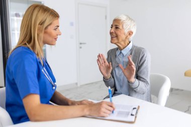Uzman Kadın Doktora Semptomları Açıklayan Kıdemli Hasta Tıbbi Danışmanlık, Sağlık Uygulaması Klinikteki Yaşlı Kadın, Klinik Tanısal Görüşme