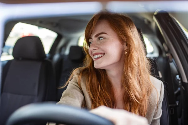 Kendine güvenen kadın sürücü kör noktaları kontrol ediyor ve bir arabayı ters çevirirken geriye bakıyor. Güvenli sürüş uygulamaları, otomotiv sigortası, sürücü eğitimi ve araç güvenliği kavramı.