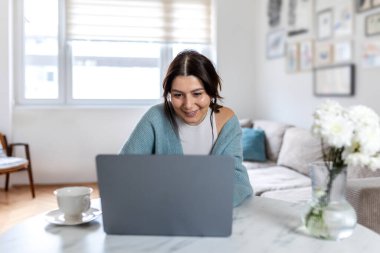 Pozitif Sanal İletişim ve Çevrimiçi İş Tatmini. Parlak Modern Çalışma Alanında Gülümseyen Neşeli Genç Profesyonel Kadın. Evde Başarılı Dijital Etkileşim.
