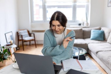 Parlak İçişleri Bakanlığı 'nda dizüstü bilgisayarda çalışan Profesyonel Kadın Girişimci. Modern İçişleri Çalışma Alanında Uzaktan İşletme Projeleri ve Dijital Stratejisi Yönetirken Odaklanmış Kadın Kalem Tutuyor.