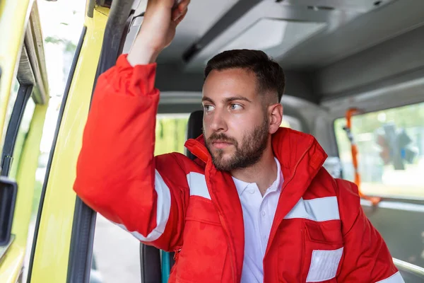Genç adam, sağlık görevlisi ambulansın yanında oturuyor. Ambulansla sağlık görevlileri. Acil çağrıya cevap vermeye hazırlanıyorum.