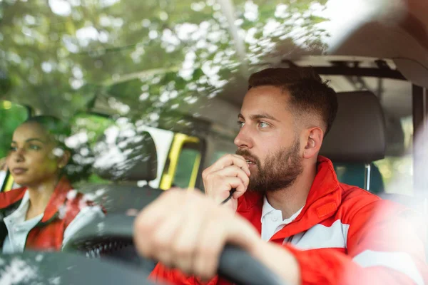 Acil bir durum. Ambulansta iki genç sağlık görevlisi var. Erkek, Kafkasyalı sağlıkçı telsizle konuşuyor.