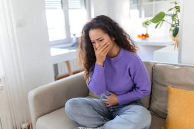 Asyalı mutsuz, rahatsız, kusmak, kusmak üzere olan hasta bir kadının yakın plan portresi. Olumsuz duygular, duygular, yüz ifadeleri. Sabah bulantısı olan Asyalı kadın..