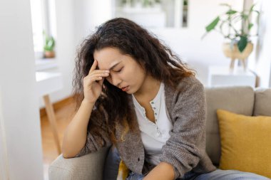 Sinus ache causing very paintful headache. Unhealthy Asian woman in pain. Sharp strong sore. Sinus pain, sinus pressure, sinusitis. Sad woman holding her head because sinus pain