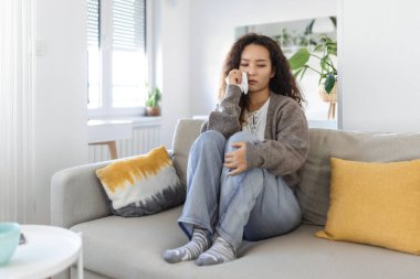 Unhappy young Asian woman crying alone close up, depressed girl sitting on couch at home, health problem or thinking about bad relationships, break up with boyfriend, divorce