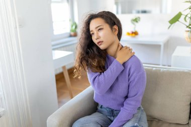 Asian woman suffering from backache at home. Lower Back Pain . Woman feels back pain massaging aching muscles, sad woman suffers from low-back