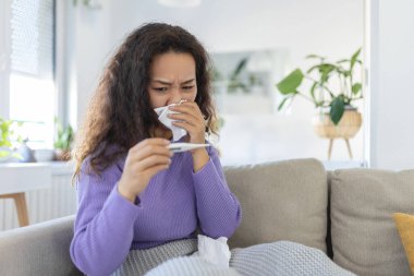Sick day at home. Young Asian woman has runny and common cold. Cough. Closeup Of Beautiful Young Woman Caught Cold Or Flu Illness.