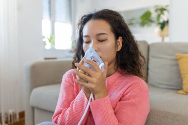 Sick Asian woman making inhalation, medicine is the best medicine. Ill woman wearing an oxygen mask and undergoing treatment for covid-19. woman with an inhaler