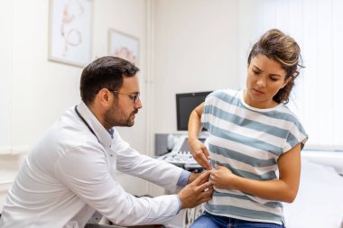 Hasta, doktora hastaneye gittiği sırada çektiği ağrıları ve sağlık sorunlarını anlatıyor. Doktorun muayenehanesinde yatarken sırt ya da böbrek ağrısı şikayeti olan genç bir kadın.