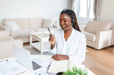 Bir iş kadınını masasında otururken görüntülemiş. Genç ve çekici bir kadının laptopunu evde video görüşmesi yapmak için kullanırken görüntülemiş.