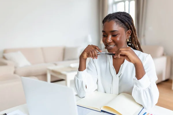 Güzel kadın serbest yazar dizüstü bilgisayarla uzaktan kumandayı planlama projesi için bilgi topluyor. Modern dizüstü bilgisayarda e-posta okurken gülen kadın .