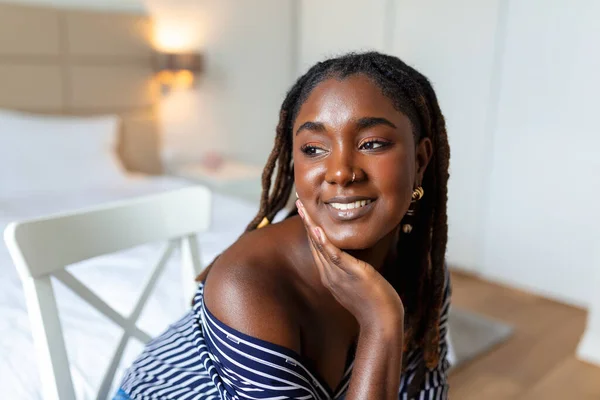 Evde gülümseyen güzel bir kadının portresi. Sıradan giyinmiş Afrikalı bir kadın fotokopi makinesiyle kameraya bakıyor. Neşeli melez kız koca bir kahkahayla evde dinleniyor..