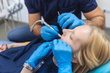 Diş sağlığı konsepti. Diş kliniğinde tedavi gören gülümseyen bir kadının kesik fotoğrafı.