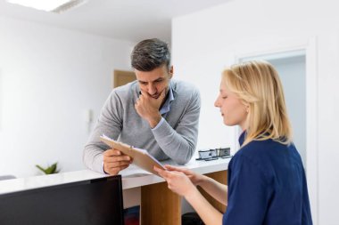 Hastalara bakıyorum. Gülümseyen adam ve neşeli dişçisi resepsiyon masasında form dolduruyorlar..