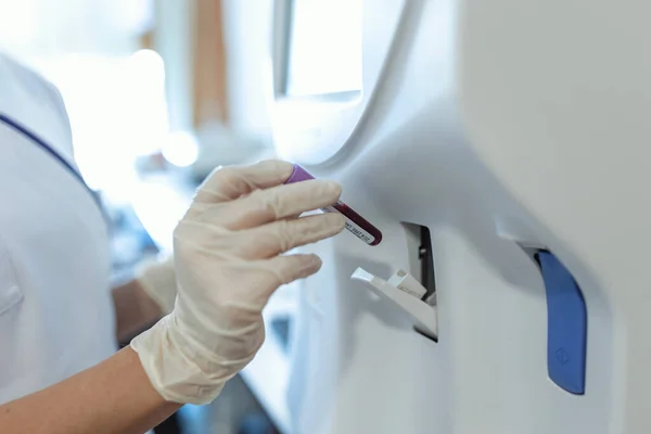 Blood hematology analyzer. Close up of medical worker in lab.